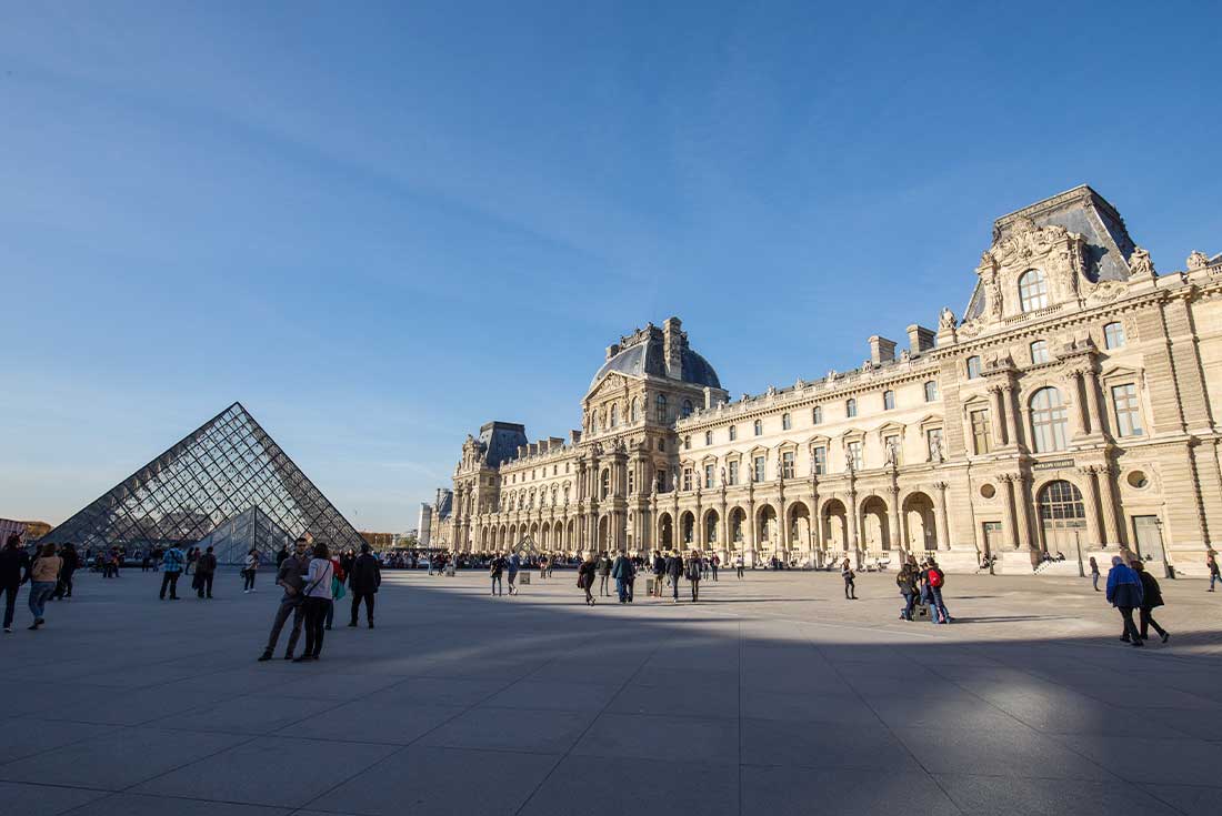 People visit the louvre on a sunny day in Paris 