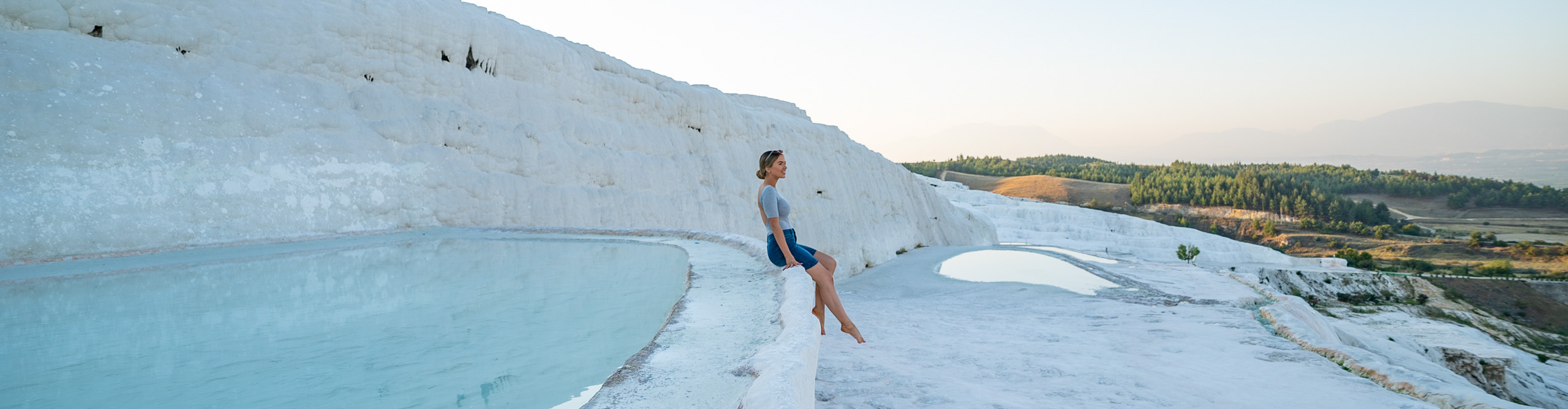 Woman sitting oat the natural spring mineral site of Pammukale, Turkey 