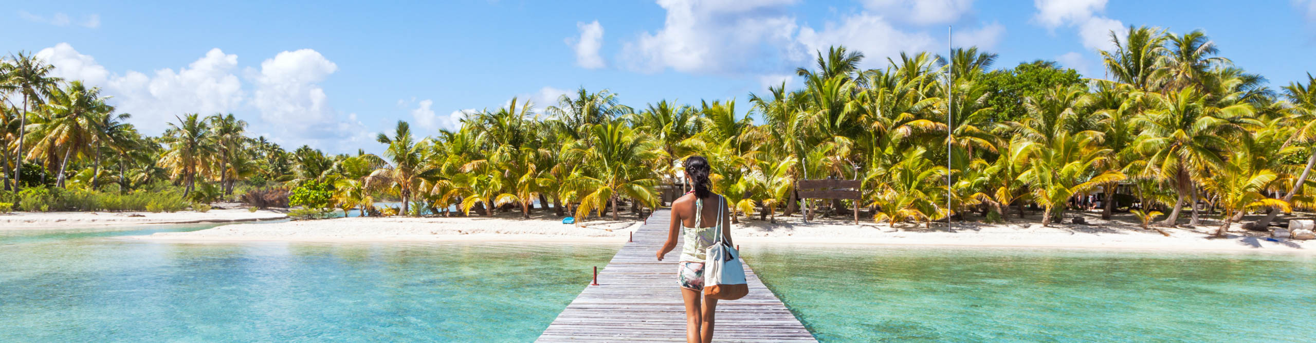 Tourist walking on jetty, Tikehau atoll, Tuamotu Archipelago, French Polynesia, Oceania
