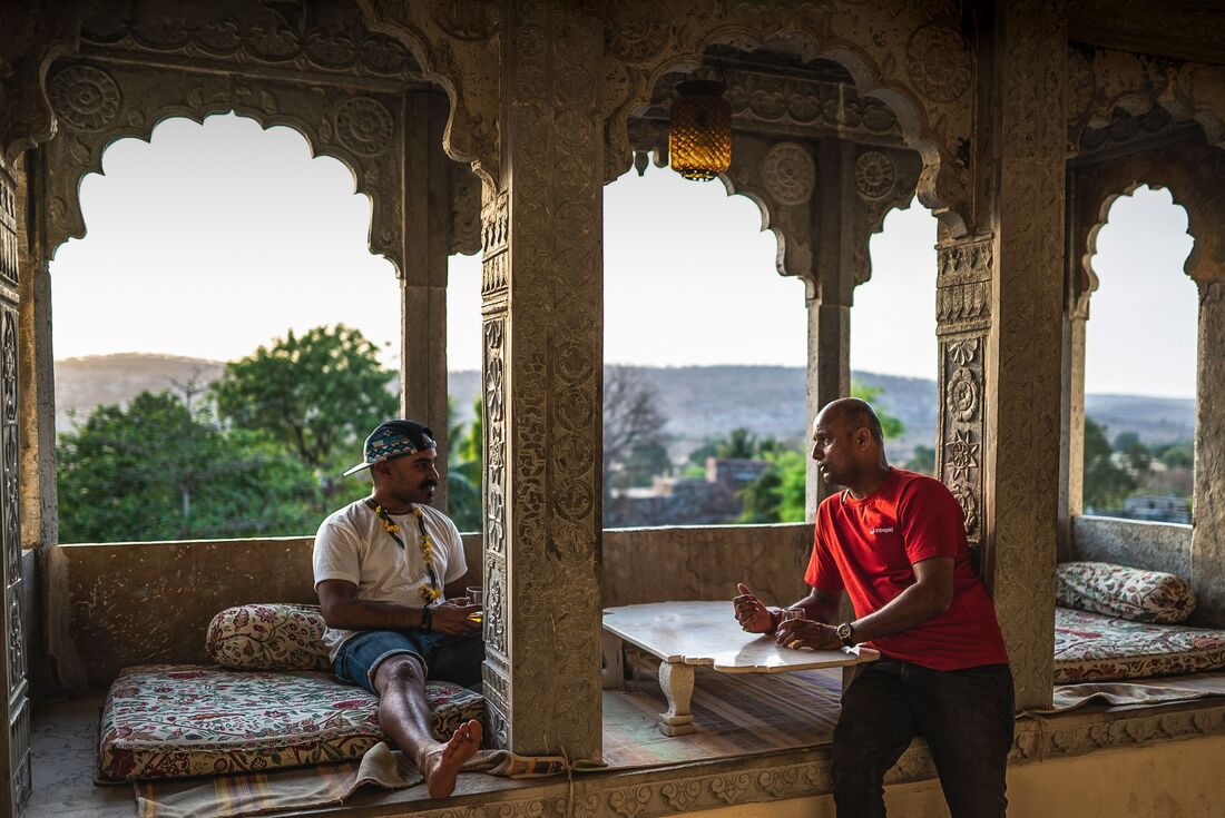 Intrepid traveller and leader relaxing and having a chat surrounded by intricately patterned interior in Jaipur