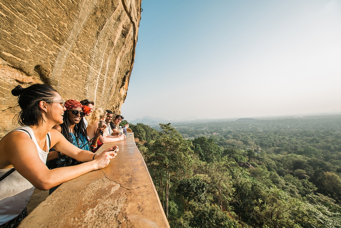 Group of travellers looking out on landscape from a scenic viewpoint on Sigiriya in Sri Lanka during an Intrepid Travel tour.