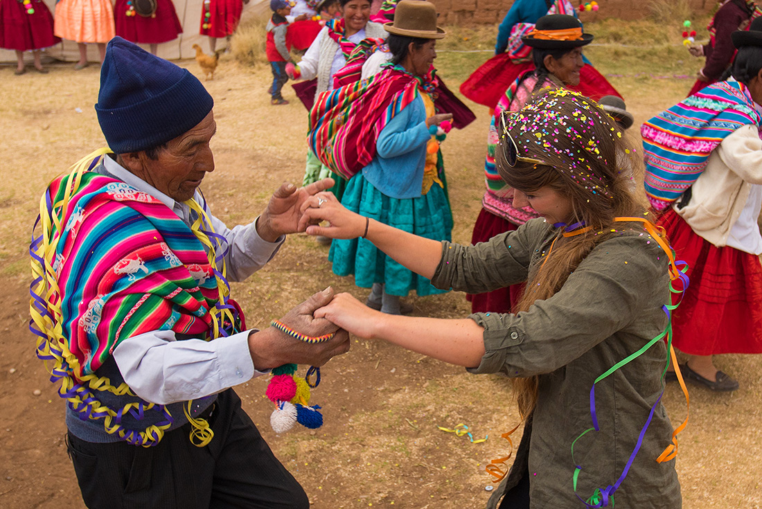 Local and traveller in traditional dance ceremony, Puno, Peru