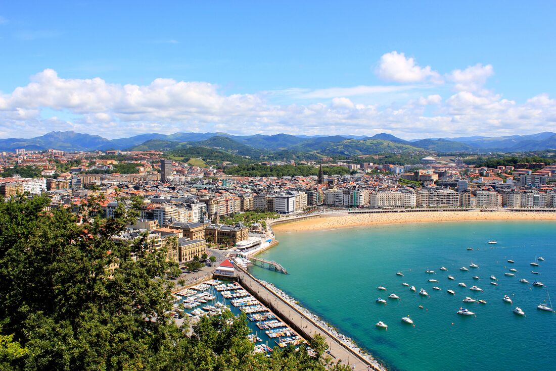 Boats in the harbour at San Sebastian, Spain, with the city and mountains behind