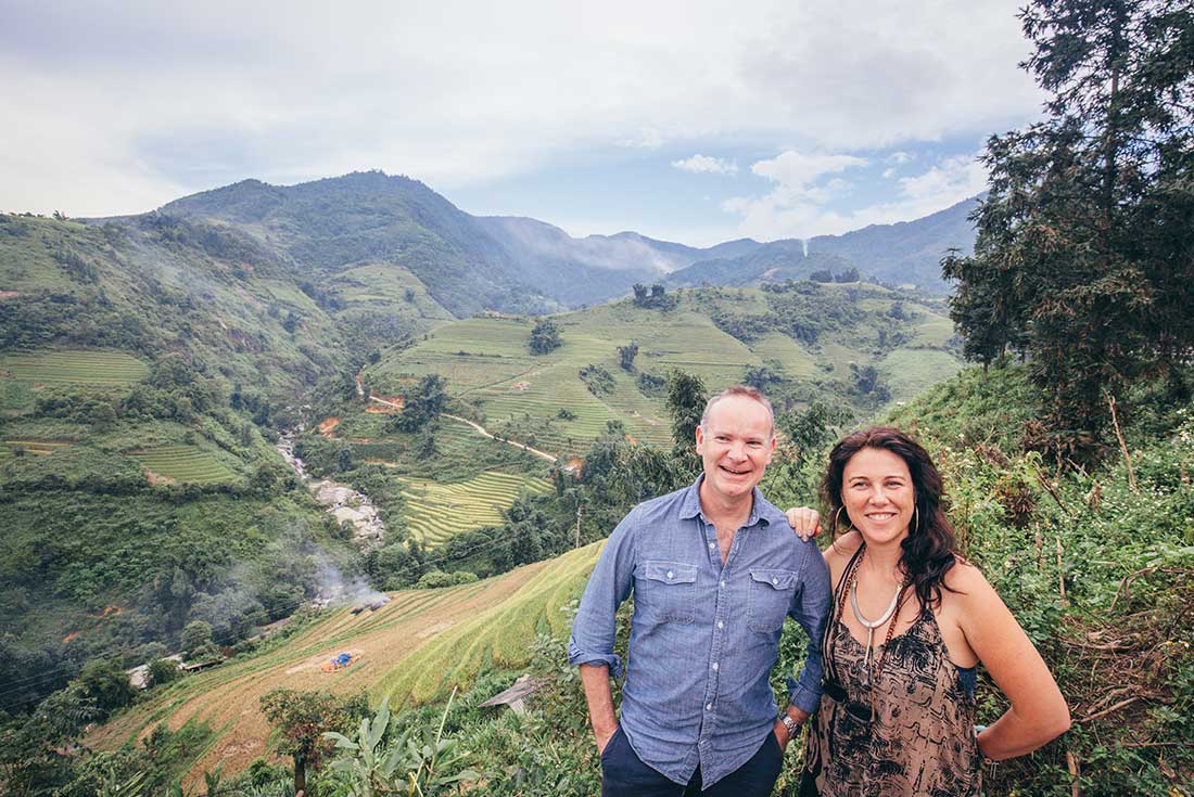 Two travellers enjoy view of the green fields of Sapa