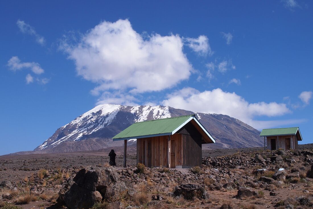 Hikers hut sits in front of view of Mount Kilimanjaro 