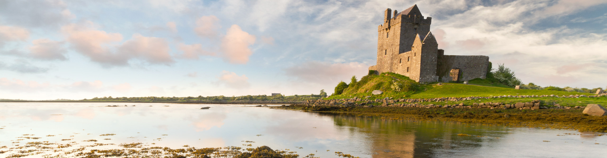 Dunguaire castle at sunset, reflected in the water, near Galway, Ireland