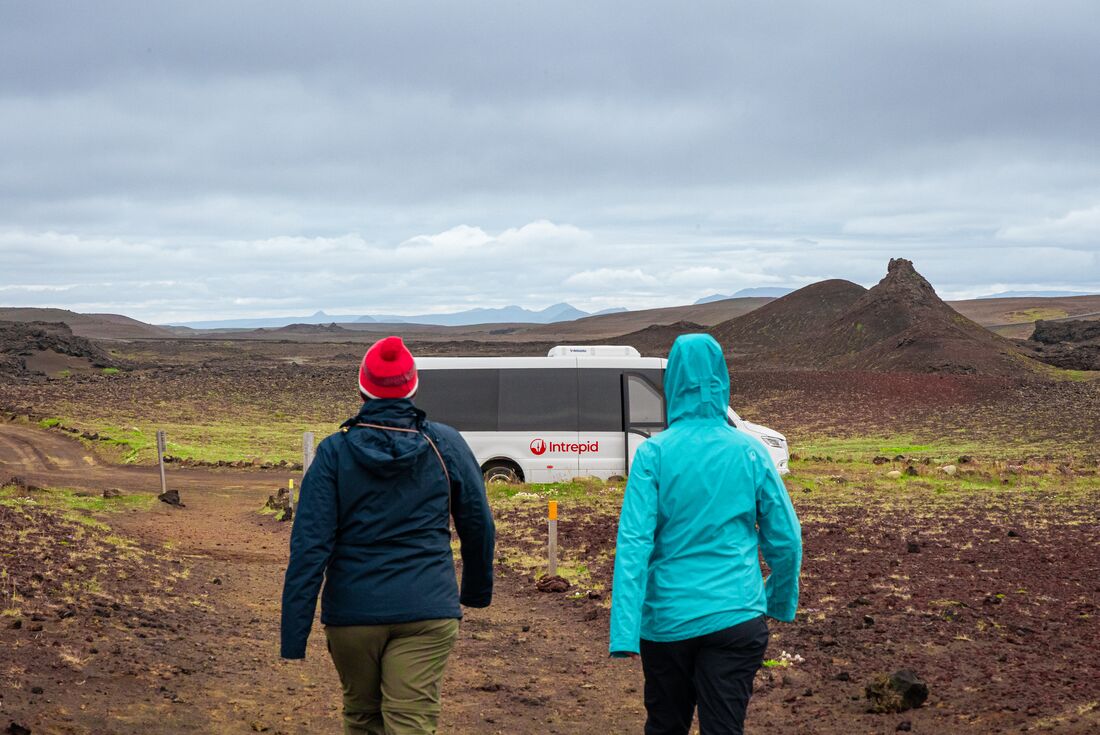 Group of travellers walk toward the Intrepid van to continue through the incredible Iceland landscape