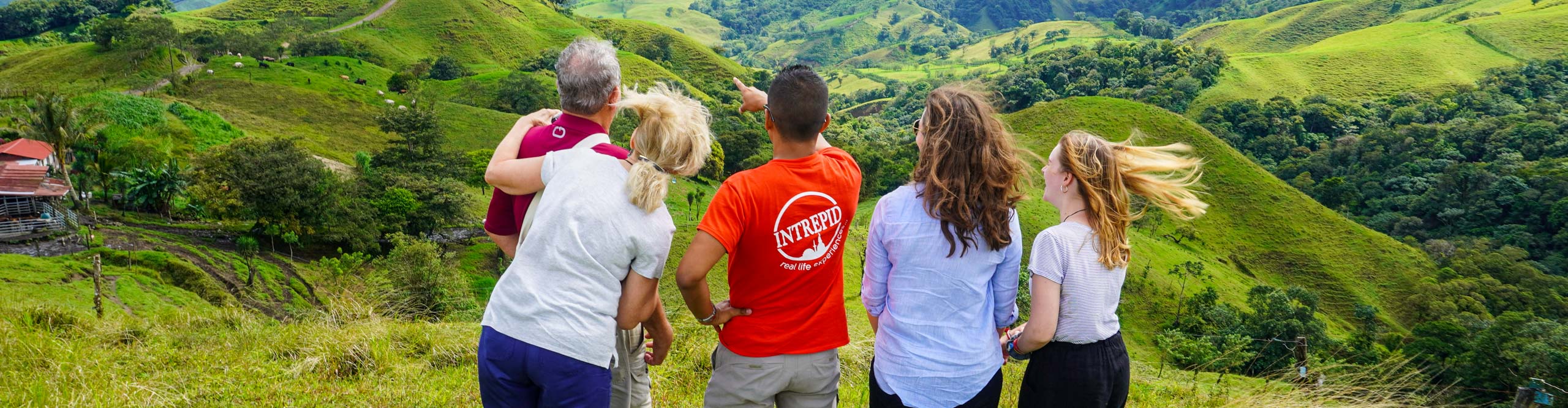 Group looking out over hills with they guide point at something of interest, Costa Rica 