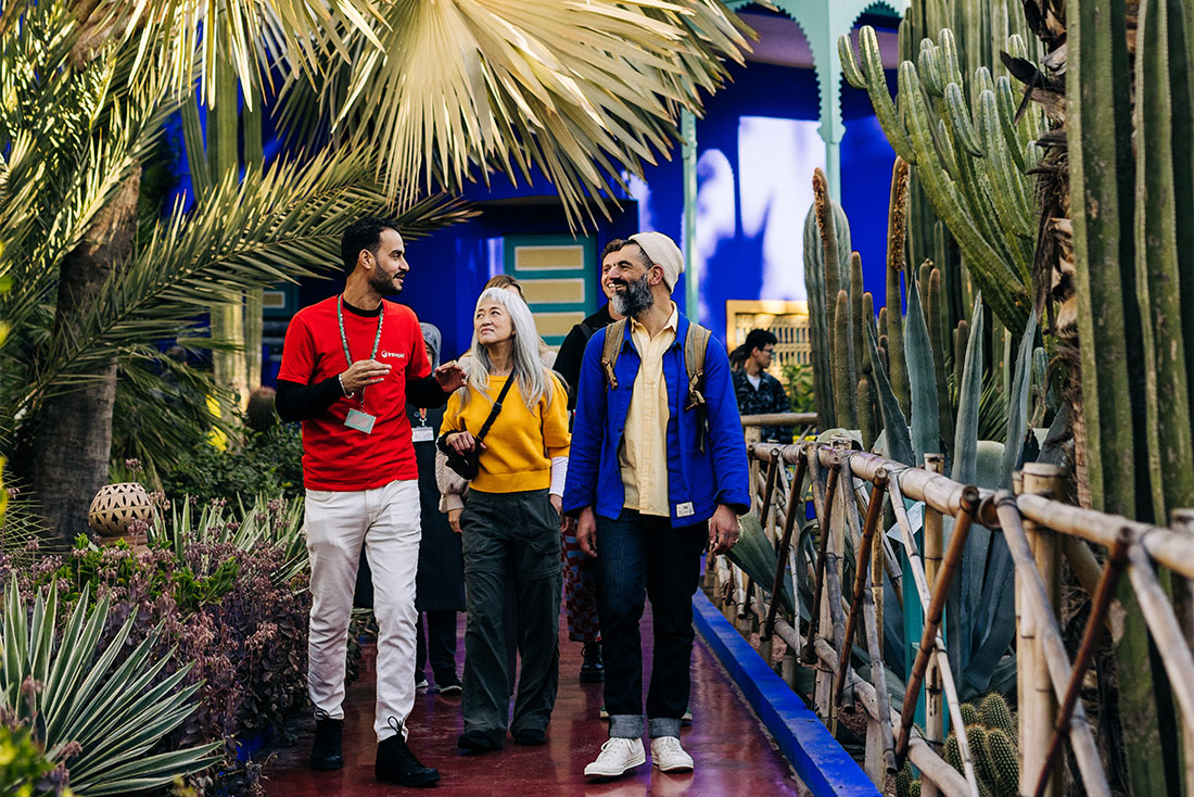 Leader and travellers walk through the vivid blue and green Majorelle Garden, Marrakech