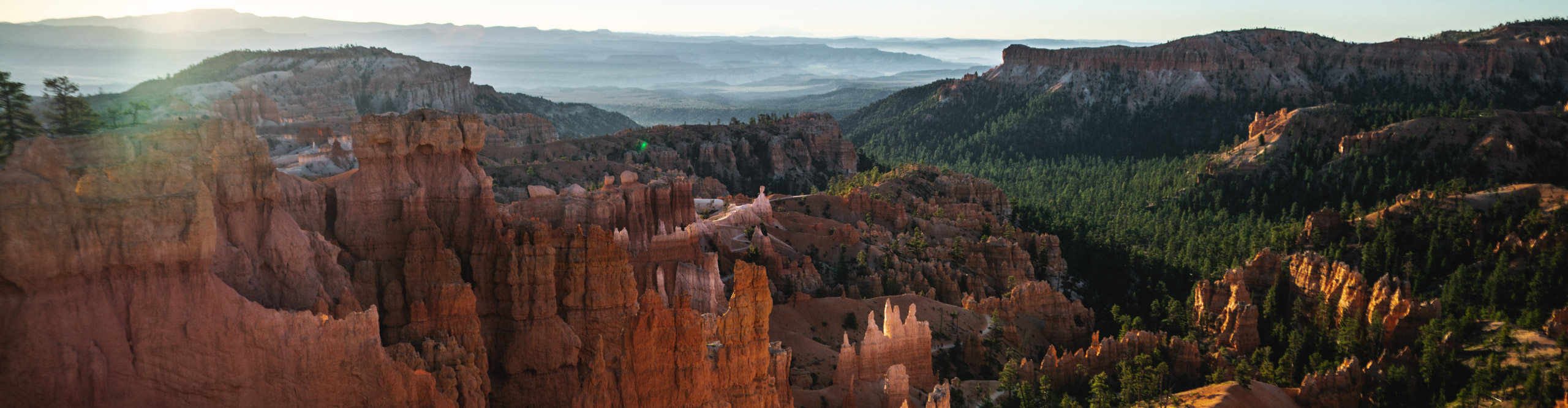Sunset over the spiky orange rock formations on a sunny day in Bryce Canyon, Utah, USA