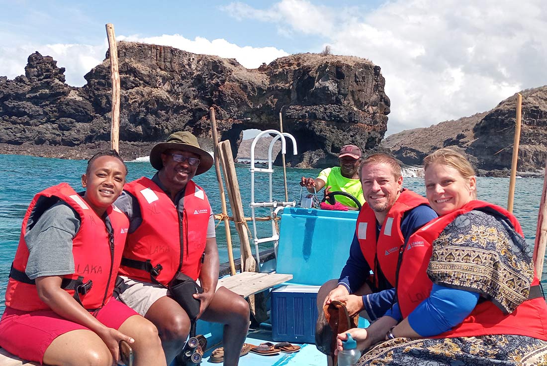 A group of travellers on a boat ride viewing natural arch in national park, Comoros Islands