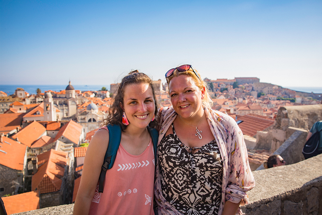 Intrepid travellers smiling with view of Dubrovnik old town red rooftops, Croatia