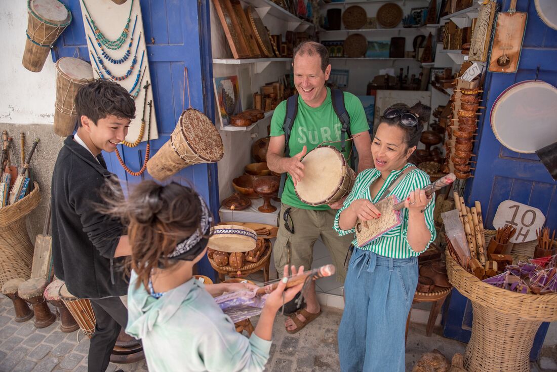 Family having fun with instruments in Essaouira market, Morocco