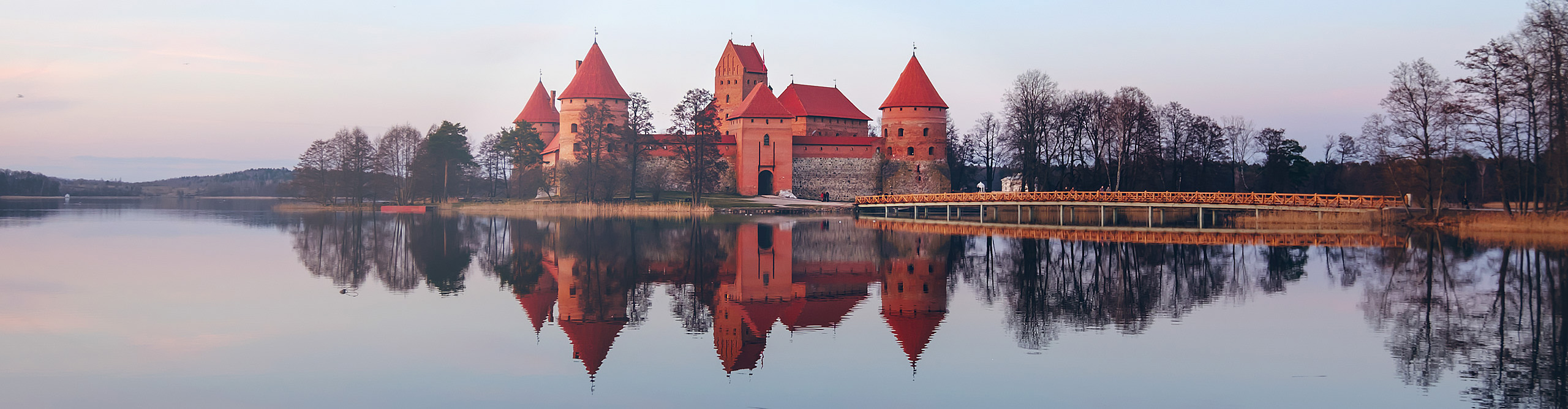 Trakai castle in early spring, reflected in the lake on a clear day at sunrise, Lithuania 
