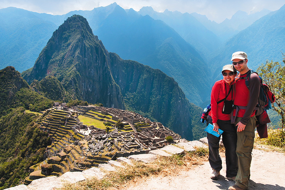Traveller couple standing with view of Machu Picchu, Peru