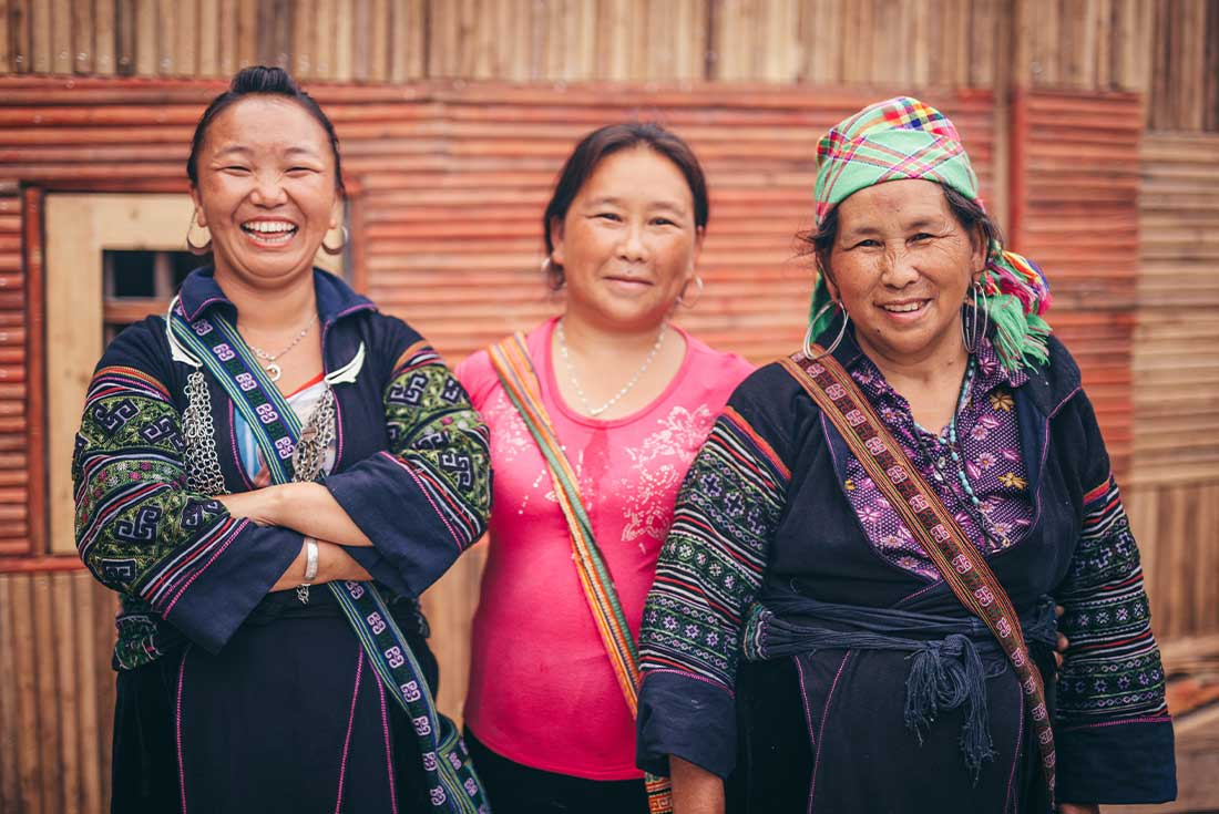 Locals in traditional dress smile and pose for camera