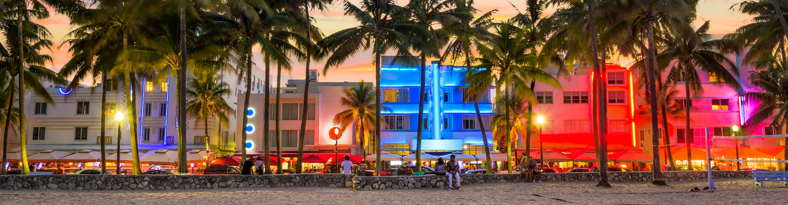 Ocean Drive at sunset, with neon lights and palm trees lining the street, Miami Beach, USA
