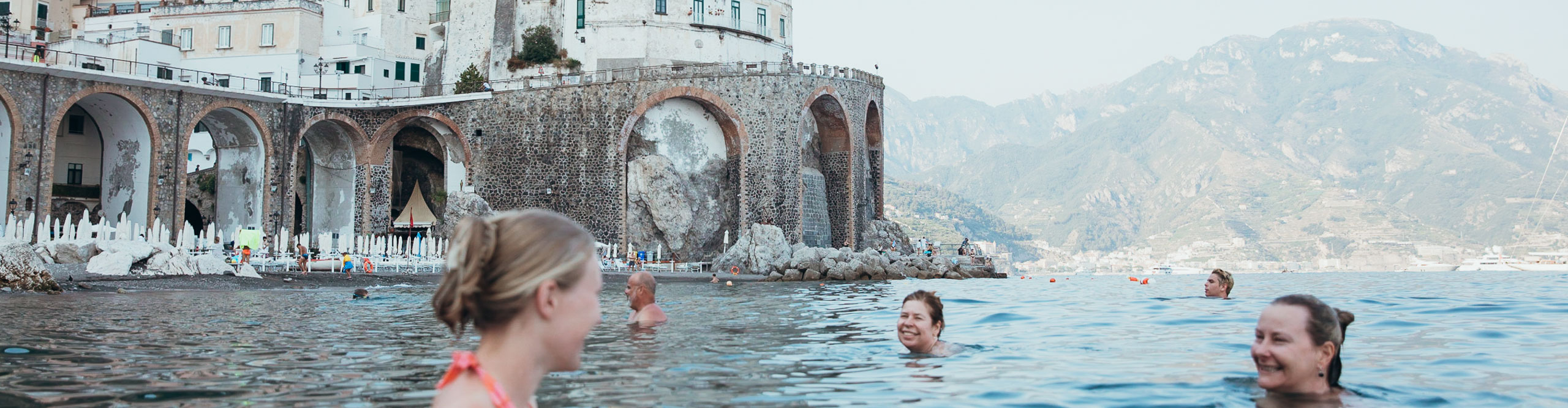 People swimming near to a fort in Italy 