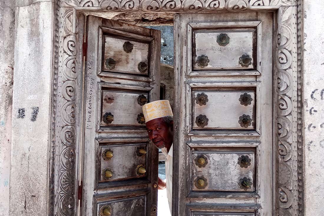 A local man peeking through the doors of a Medina in Moroni, Comoros Islands