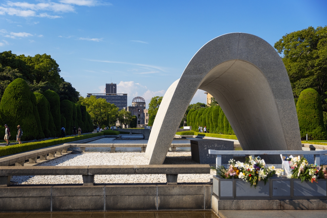 Closeup of arch in Hiroshima Memorial Peace Park with the A-Bomb Dome visible in background
