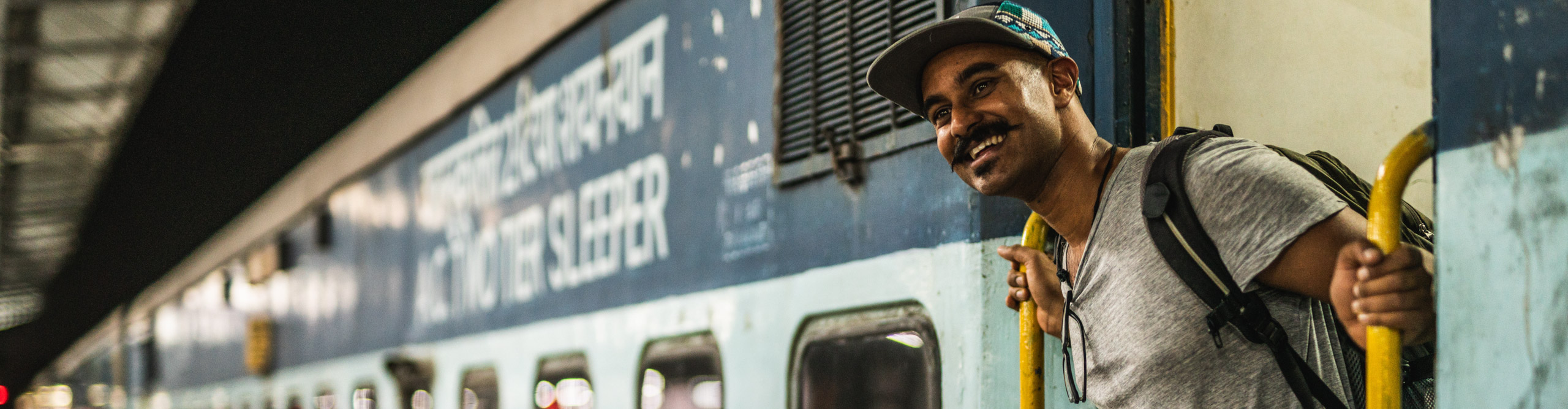 Man standing in doorway of train in India 