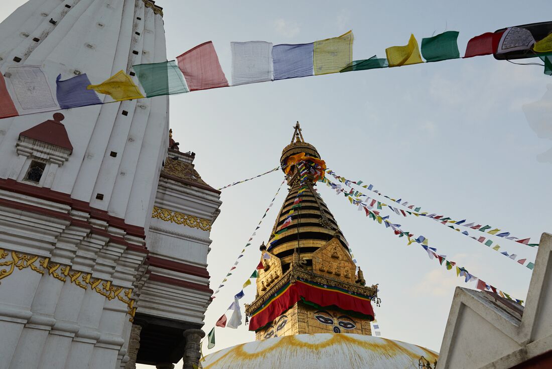 Prayer flags attached to buildings, viewed from below in Kathmandu, Nepal