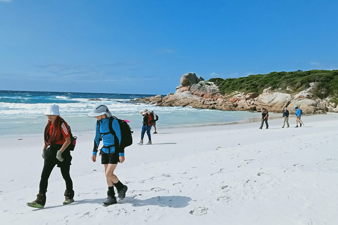 Group of travellers hiking the Bay of Fires, Tasmania, Australia