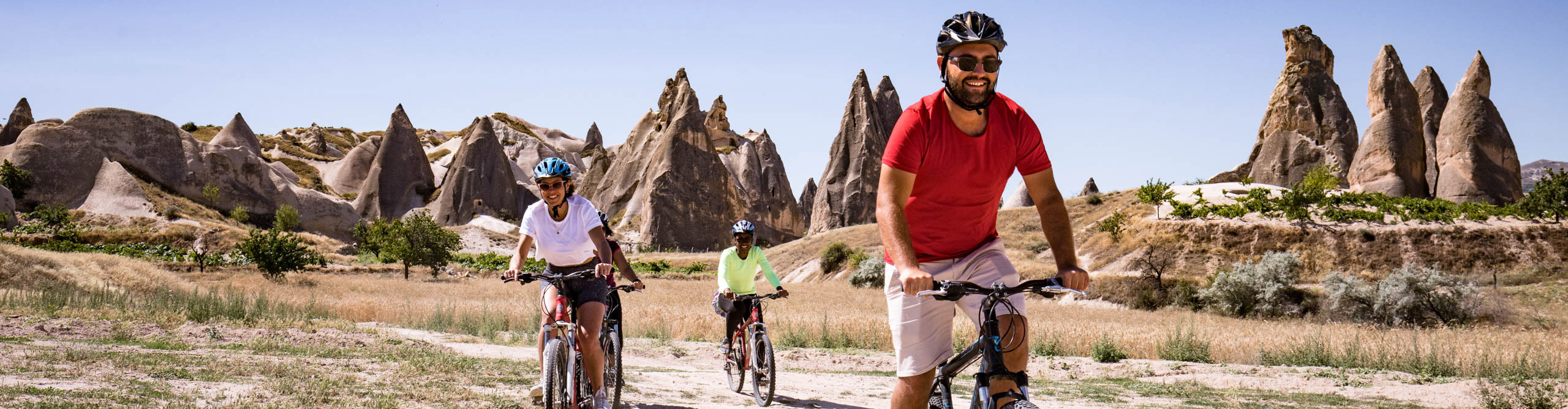Tour guide riding with guests through the landscape in Cappadocia, on a sunny cloudless day 