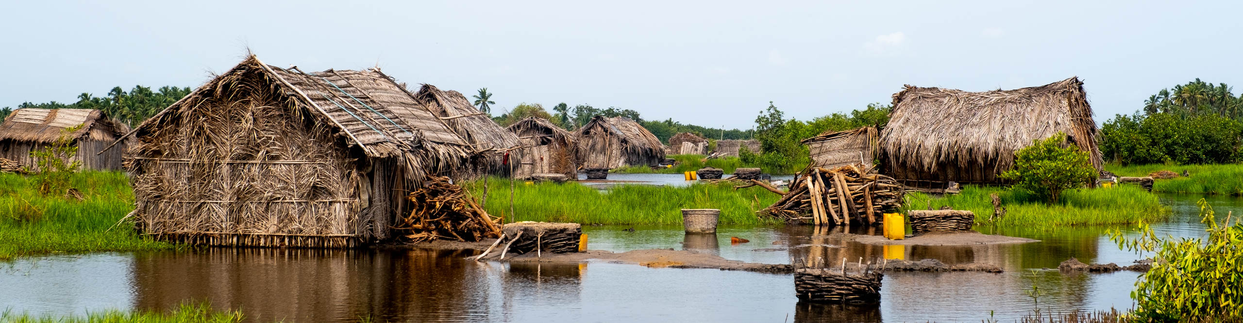 A villager of houses with straw walls and roofs built on the river in. Benin, West Africa 