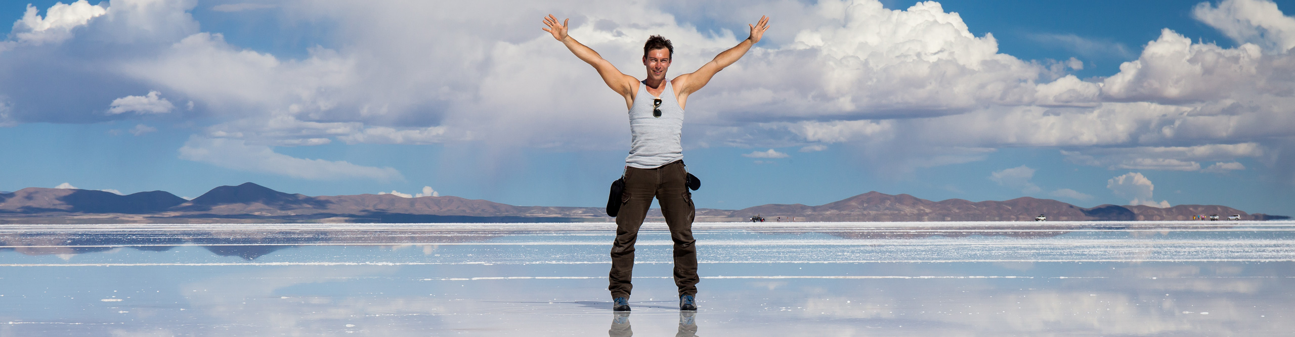 Man staning with arms outstretched on the Salt Flats of Uyuni, Bolivia, on a clear sunny day