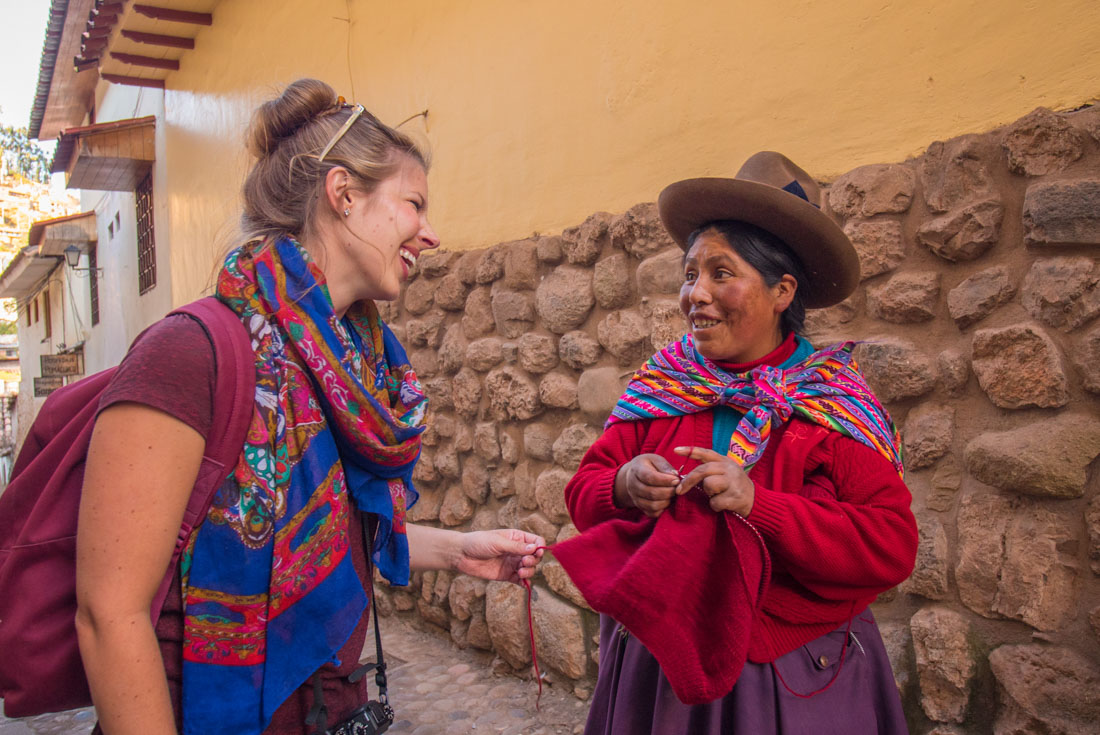 Intrepid traveller talks to a traditionally dressed local in the streets of Cusco