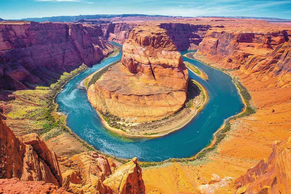 Stunning view of sand coloured rocks and blue waters of Horse Shoe Bend in Arizona