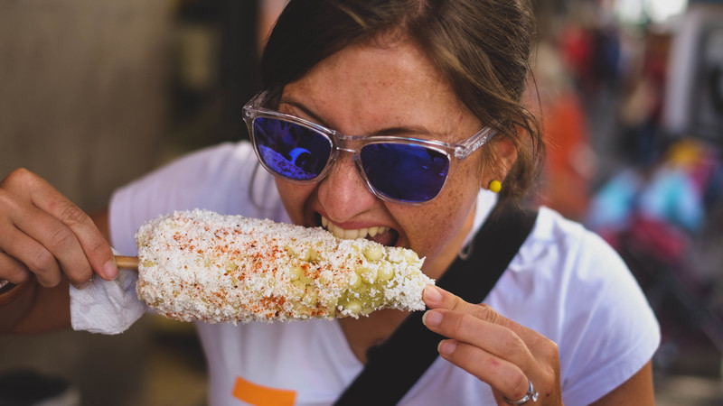 Woman bites into corn cob