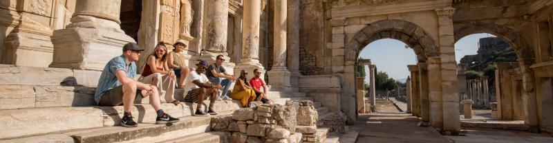 Travellers sit on the steps of Ephesus, Turkey