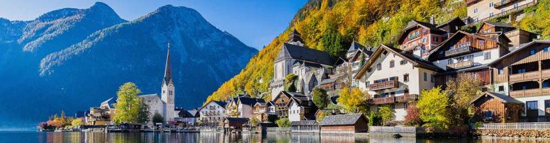 Houses and gothic church in the mountain village of Hallstatt, Austria, reflected on lake 