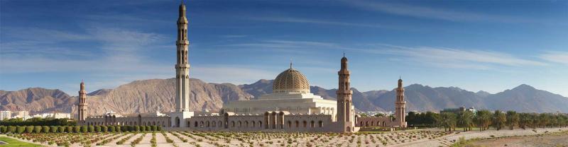 Wide view of the Grand Mosque in Muscat, Oman, with mountains in background