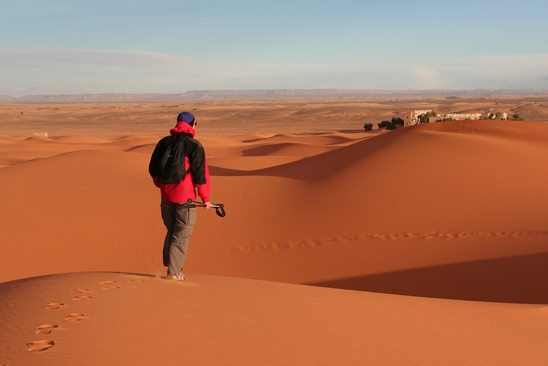 UBPN - Traveller trekking through dessert, Sossuvlei, Namibia