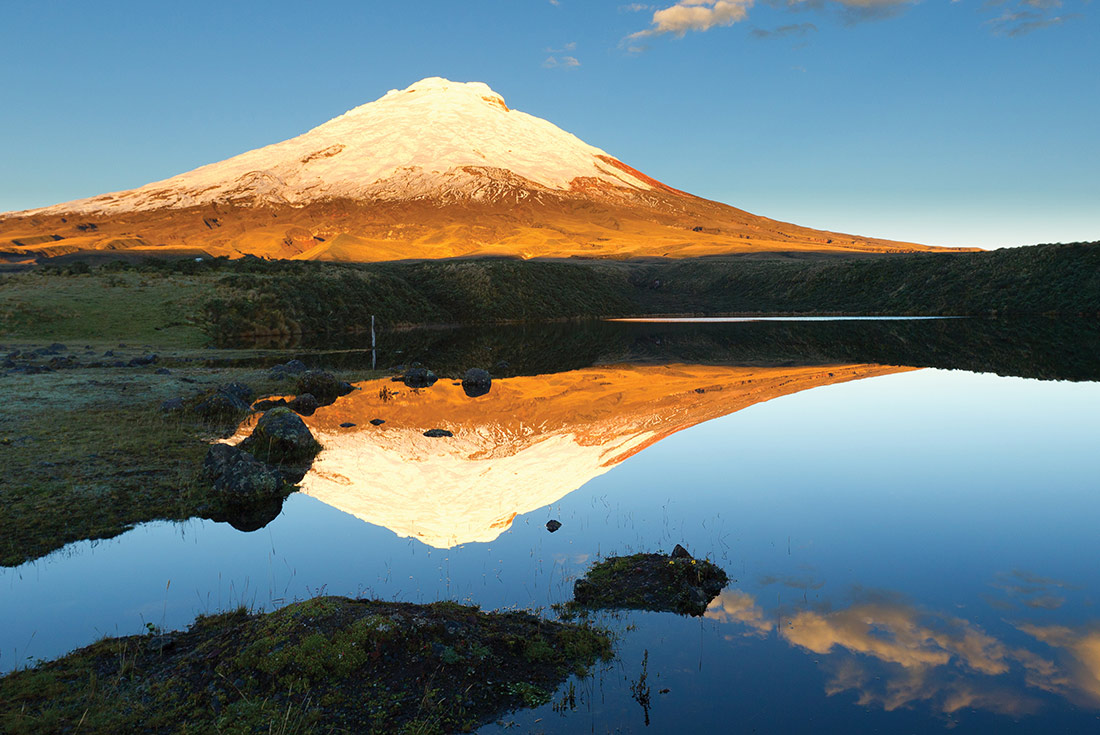 View of Cotopaxi volcano and a reflection of it in the lake in front of it, Ecuador