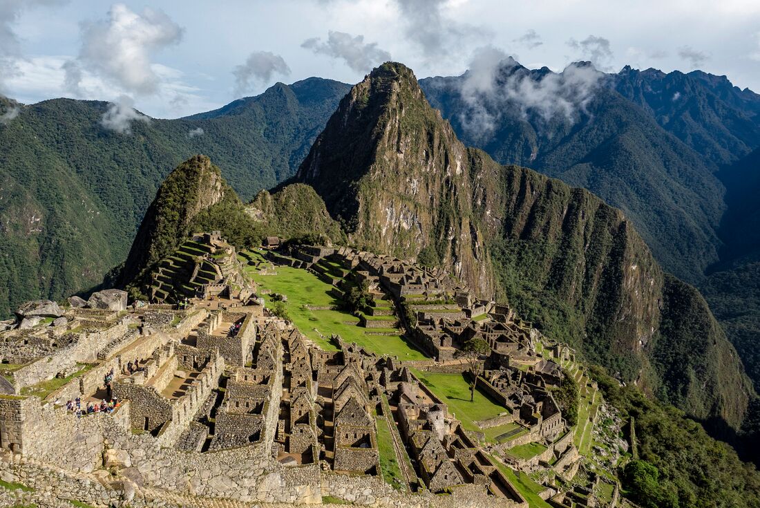 Panoramic view of Machu Picchu on mountaintop surrounded by other mountain peaks in Peru
