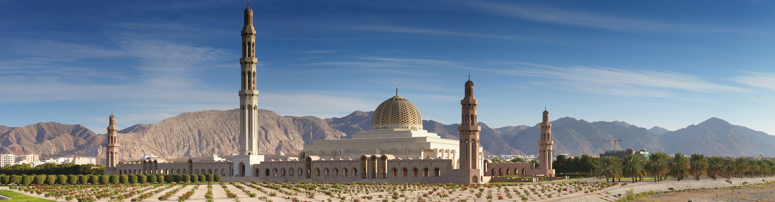 The Grand mosque, Muscat, Oman on a clear sunny day with mountains in the background 