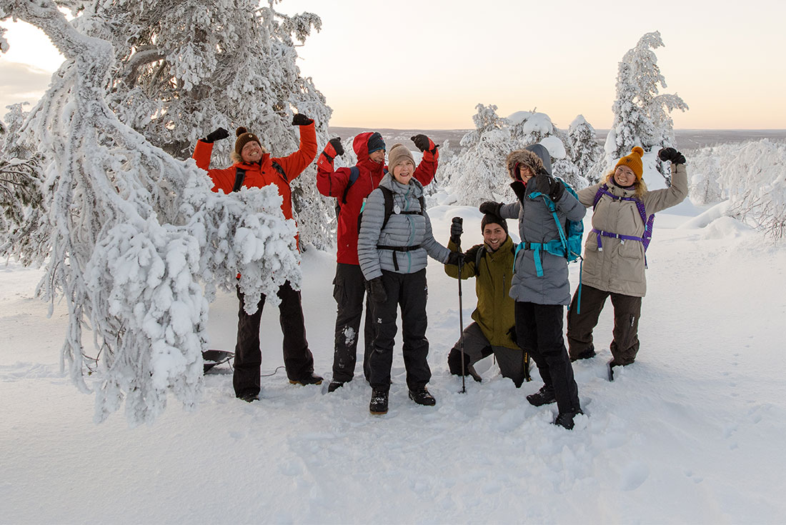 Intrepid travellers pose at the peak of a winter hike in Finland 