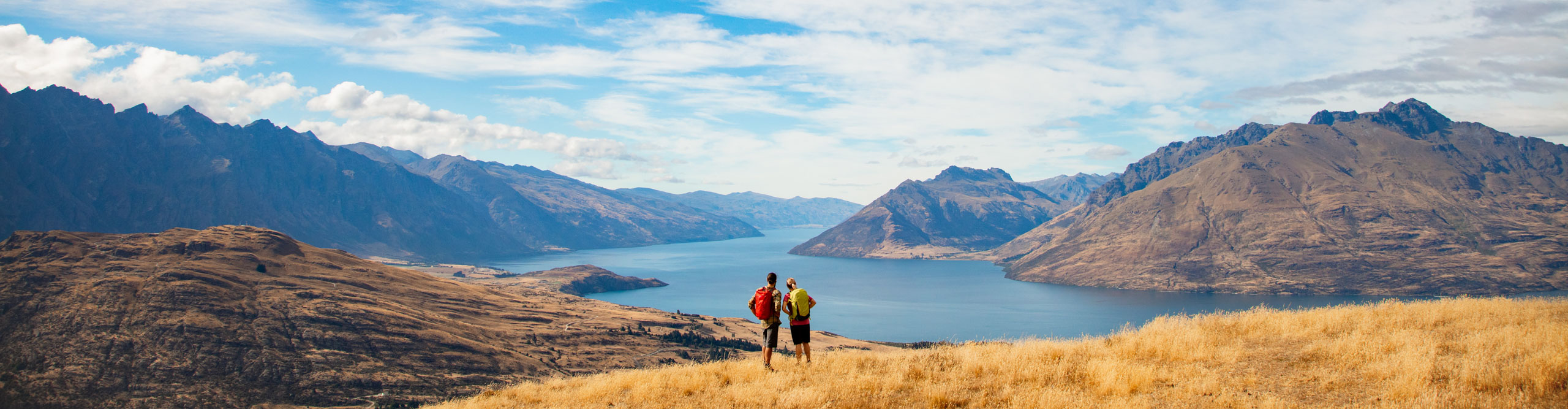 Hiker admiring the view of the Remarkables mountains and Lake Wakatipua, Queenstown, New Zealand