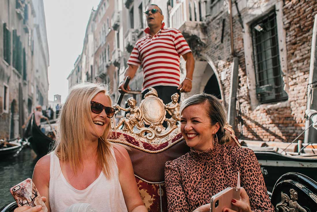 Two passengers take a gondola ride in Venice