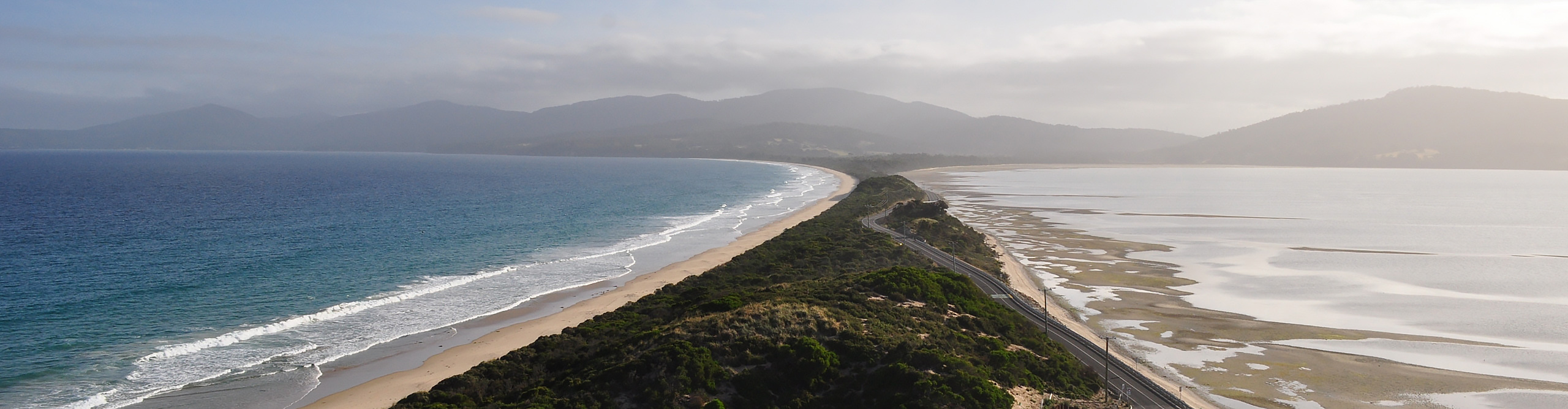 The narrow isthmus called The Neck, with open ocean one side, in Bruny Island, Tasmania.