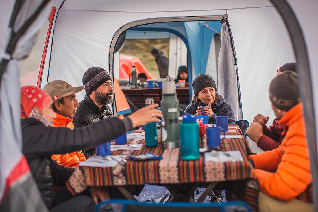 Group enjoying a warming drink in the campground on the Great Inca Road, Peru