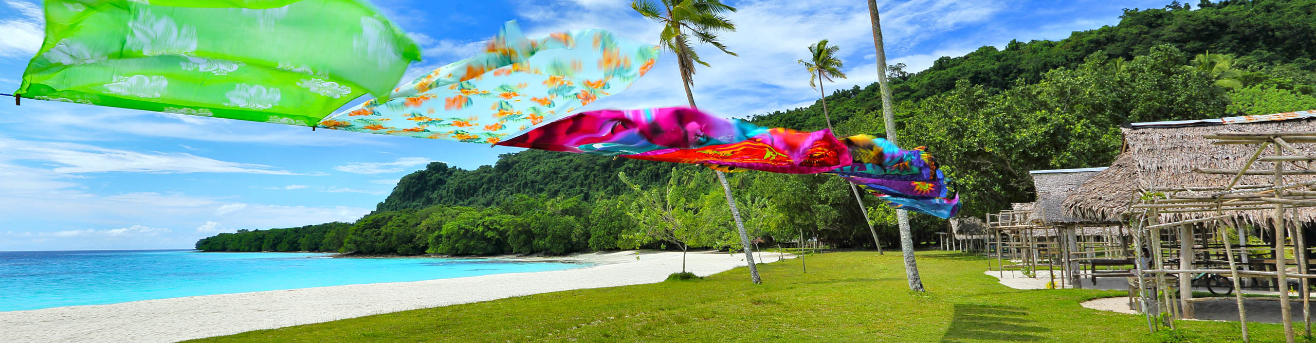 Colourful Table cloths drying on cloths line with lunch huts, best beach on Espiritu Santo Island