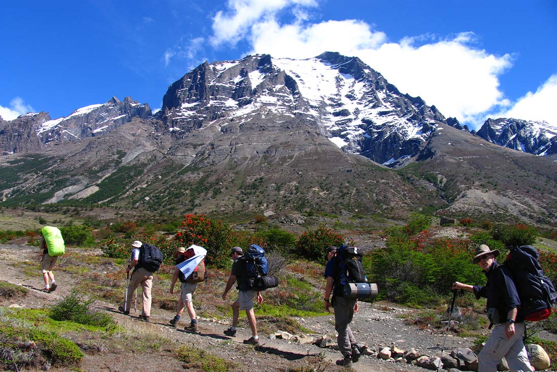 Group of travellers hiking alongside mountains, Torres del Paine NP