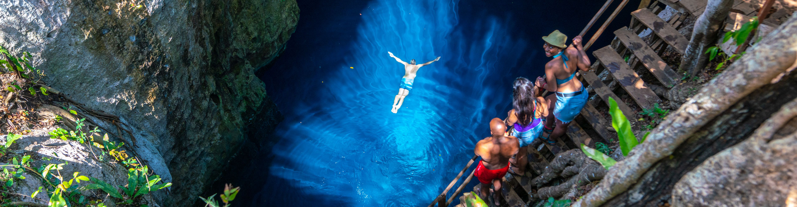 People swimming in bright blue lagoon in Mexico 