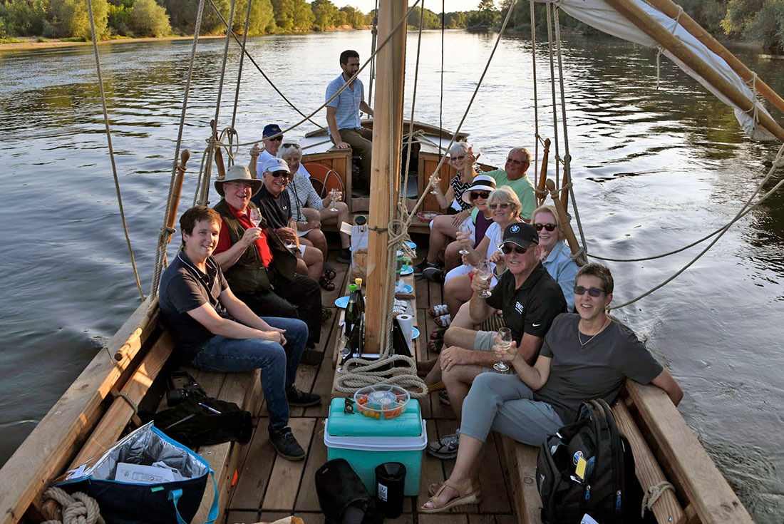 Group of Intrepid travellers relax during a winte tasting on the river at Chateau Gaudrelle