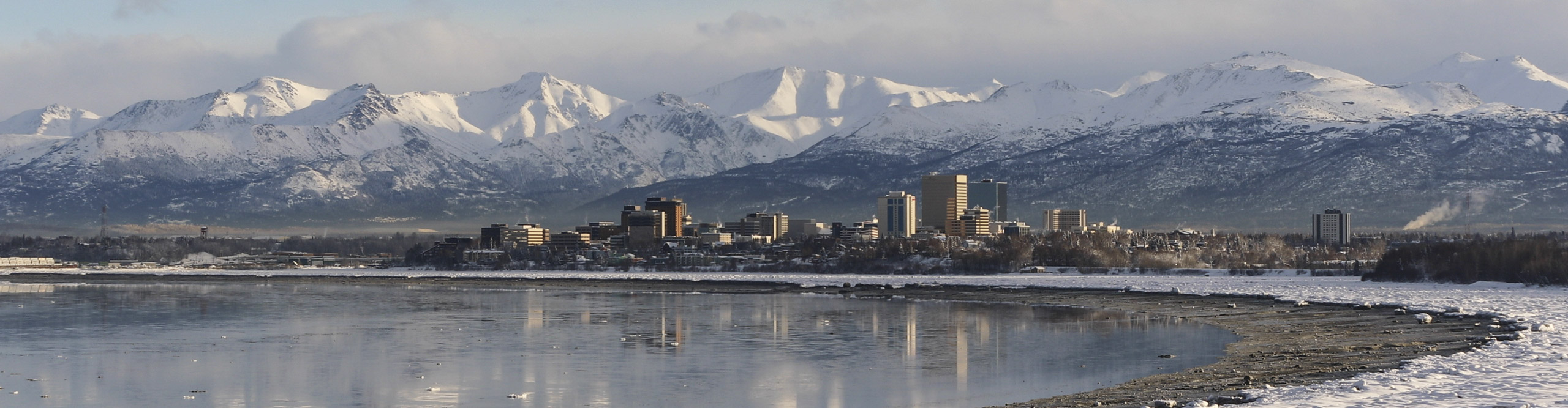  Anchorage skyline with mountains behind it covers in snow, Alaska, USA